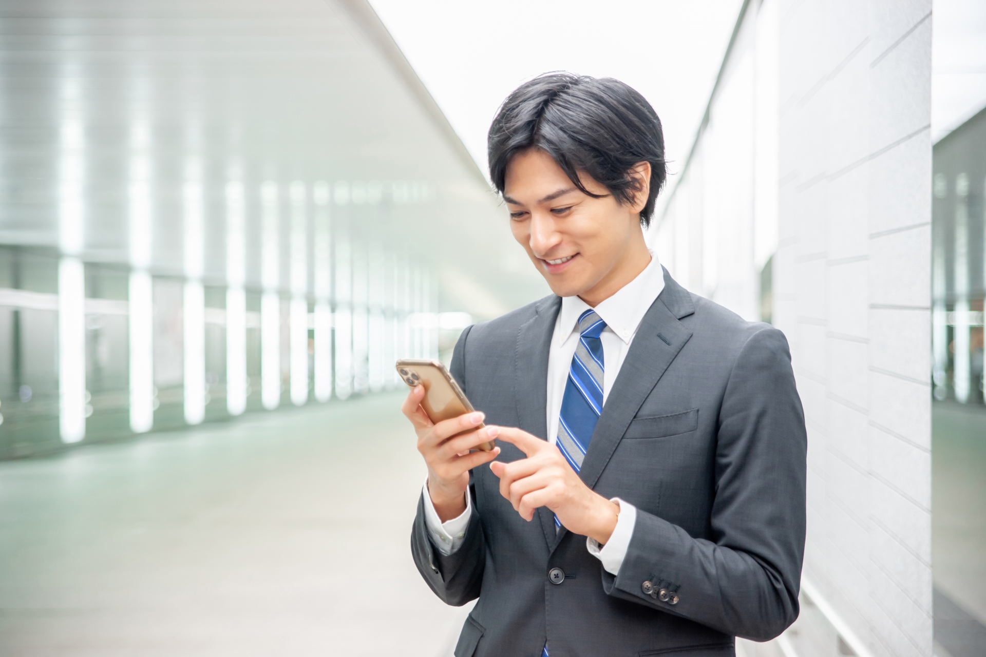 笑顔でスマートフォンを見るビジネスマン