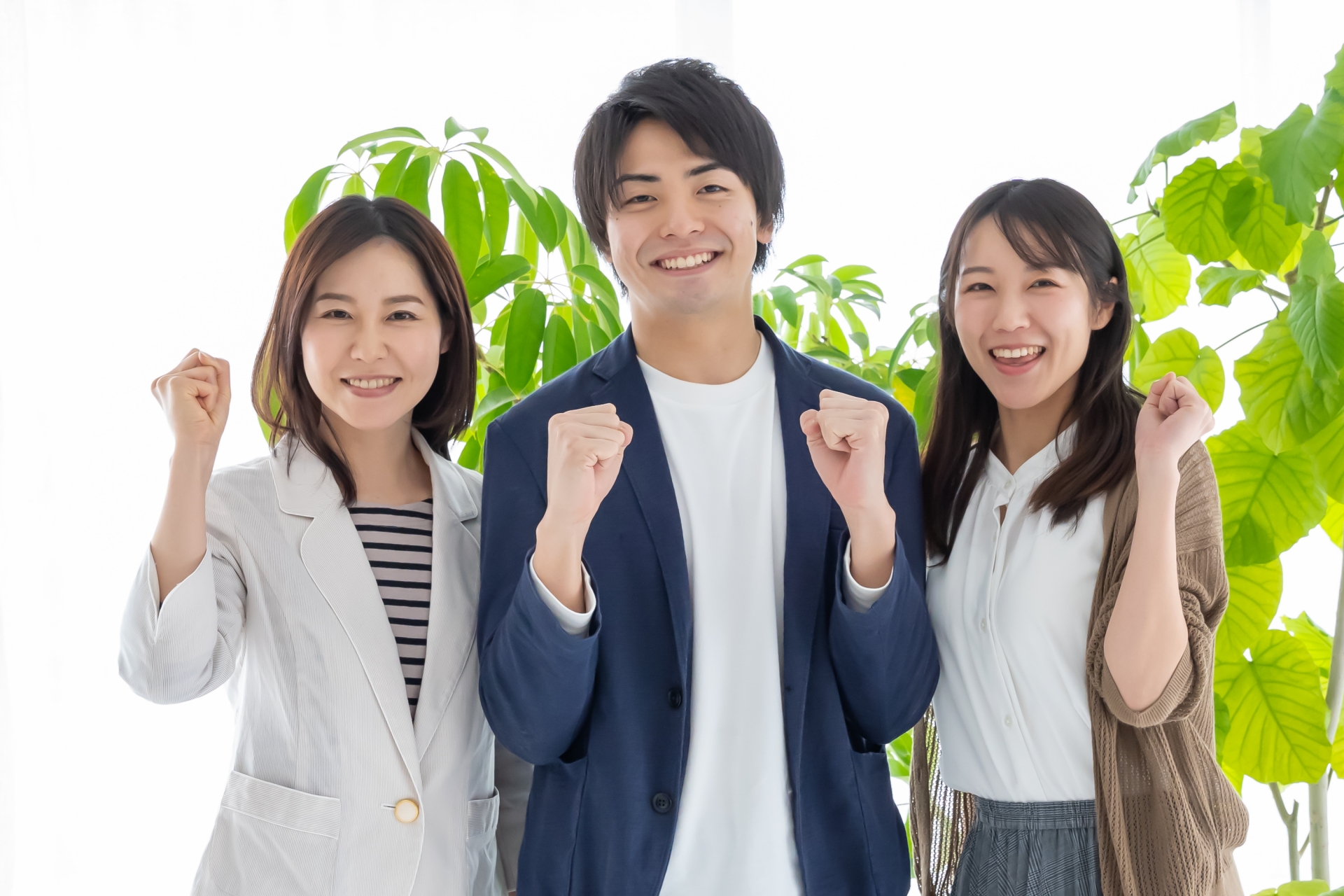 笑顔でガッツポーズをとるビジネスパーソン