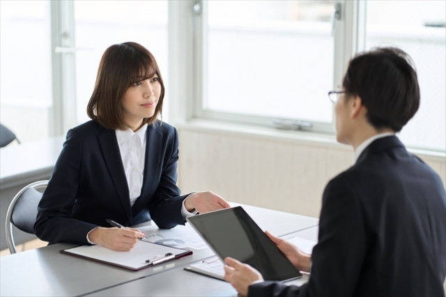 向かい合って打ち合わせをする男女