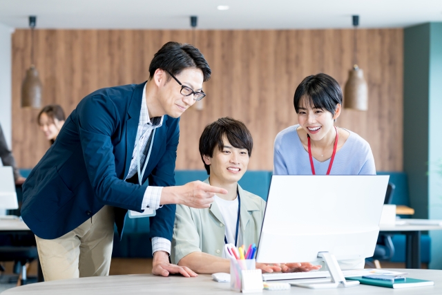 笑顔で若手社員に指導する男女