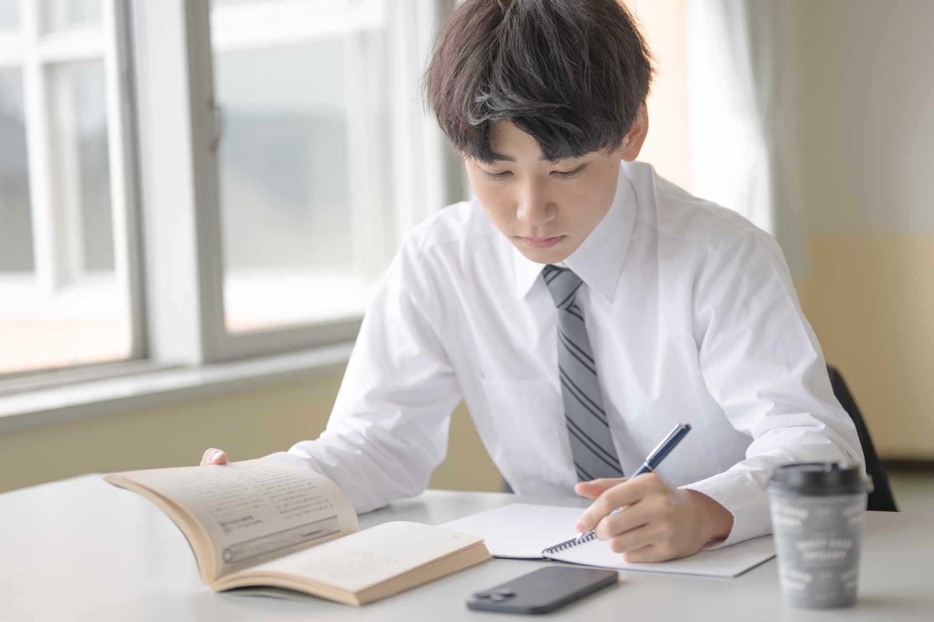 本を手に勉強をするビジネスマン