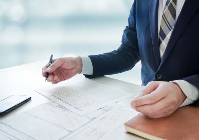 机に広がる書類とビジネスマン